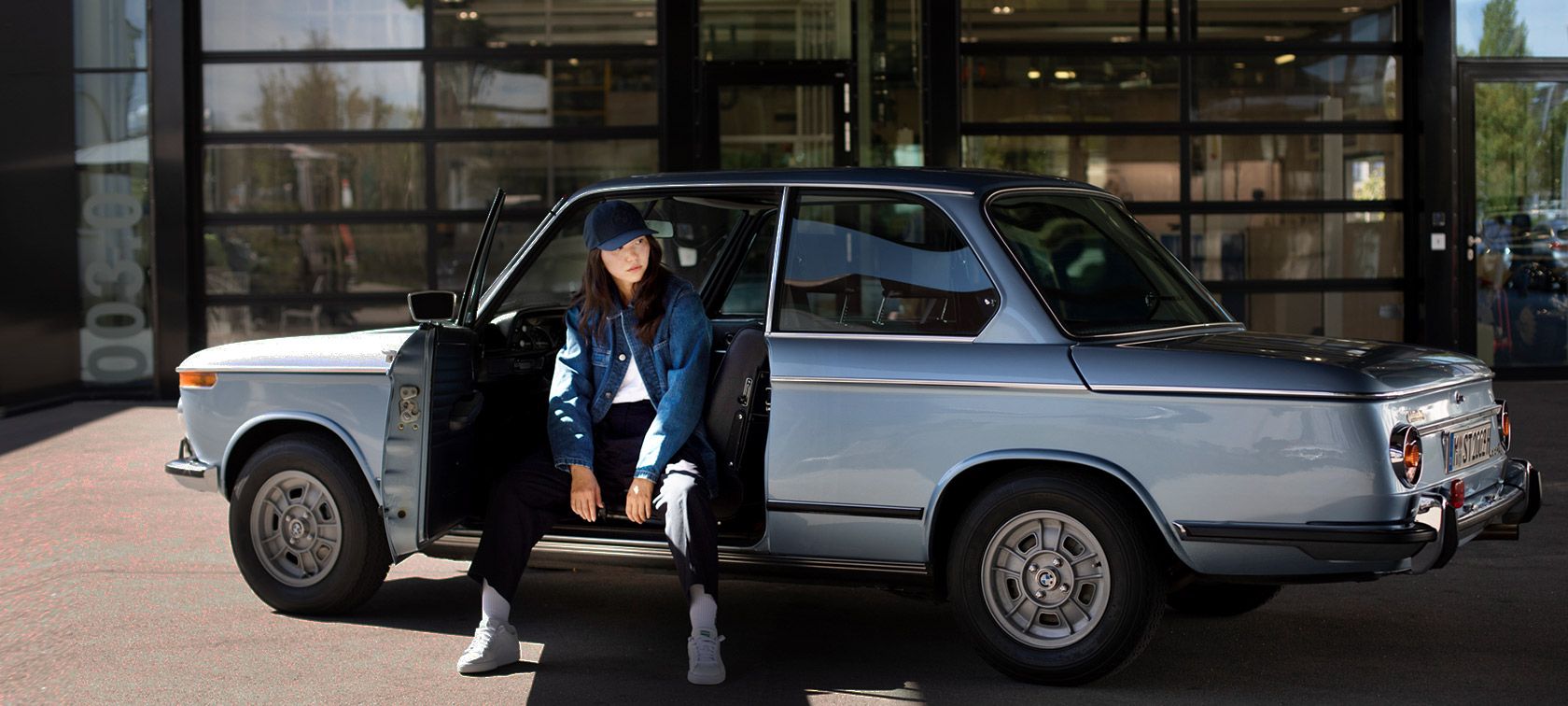 Lány BMW Lifestyle kollekciós ruházatban ül egy BMW-ben Lány BMW Lifestyle kollekciós ruházatban ül egy BMW-ben